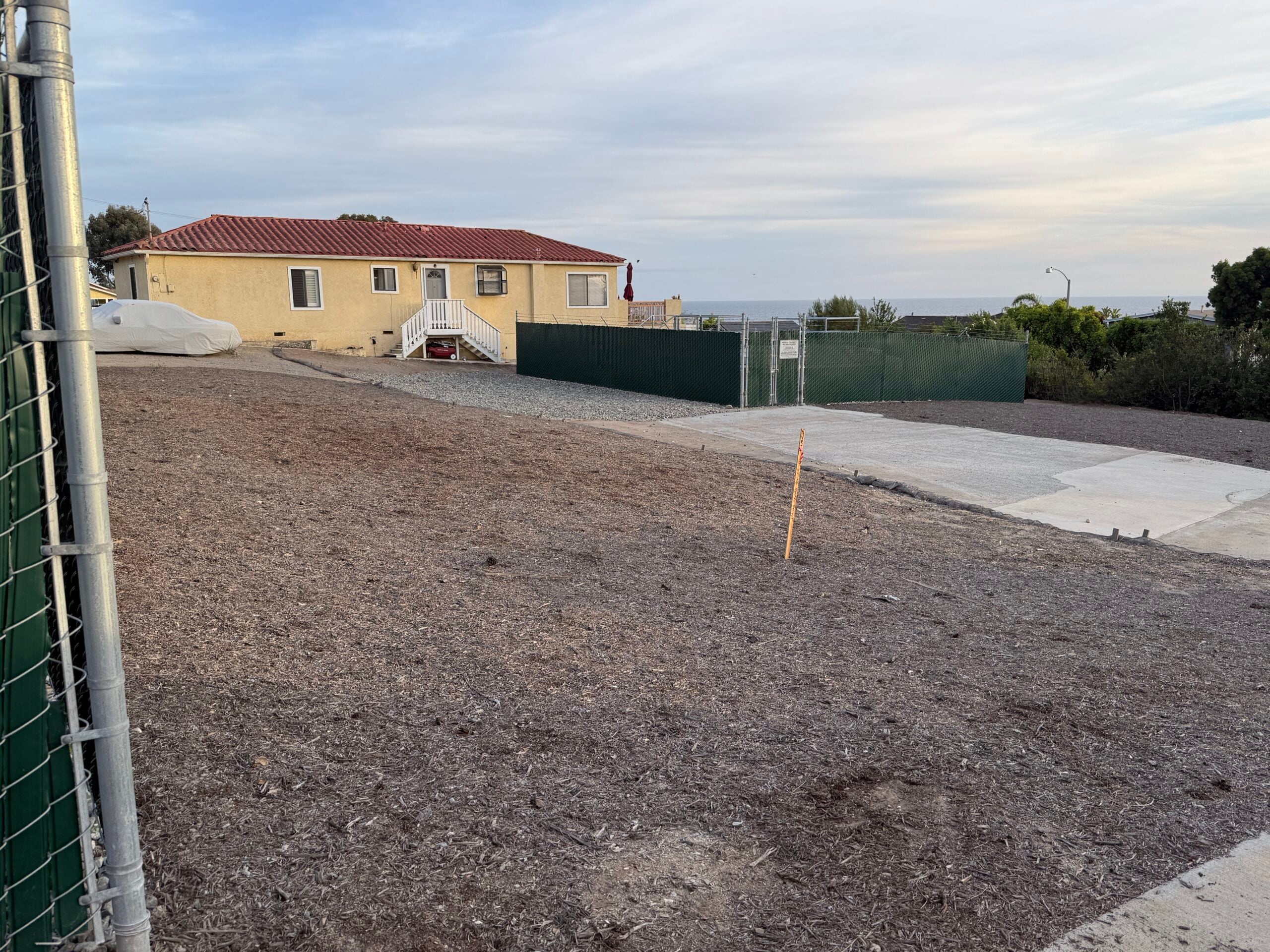 Street view of the derelict SCWD site at 31762 Coast Hwy in South Laguna, showing a dirt lot, chain link fence, and unmaintained structures, April 20, 2026. Non-compliant with CUP and CEQA requirements.