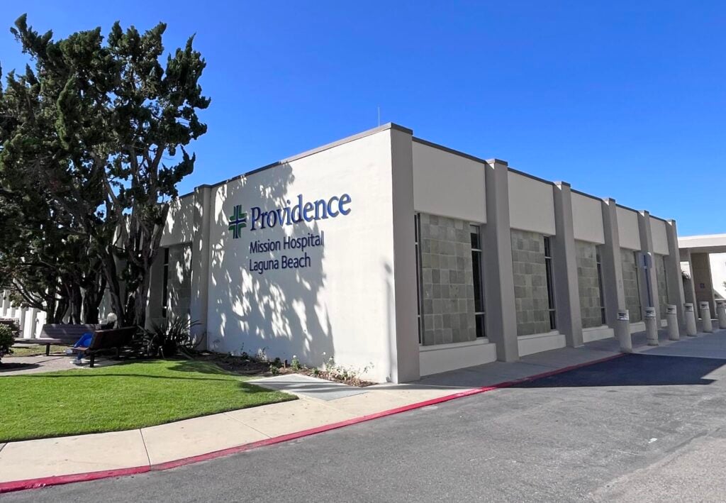 Exterior view of the Providence Mission Hospital Laguna Beach building entrance, highlighting the facility that is currently facing a phase-out of its Emergency Room and acute care services.