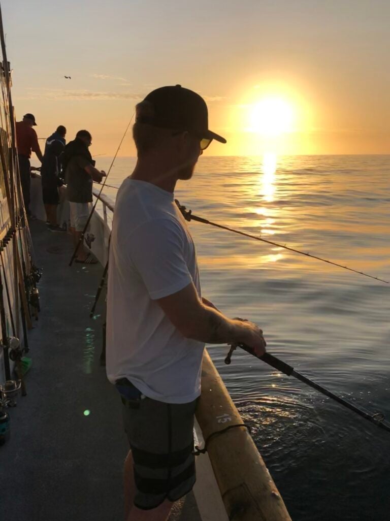 Michael Kovach recreational fishing from a charter boat off the coast of Dana Point at sunset.